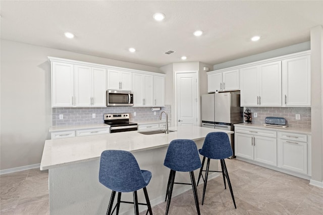5065 Sparkling Water Way, Kissimmee, FL 34746 - kitchen with stainless steel appliances, tasteful backsplash, a breakfast bar, an island with sink, and recessed lighting