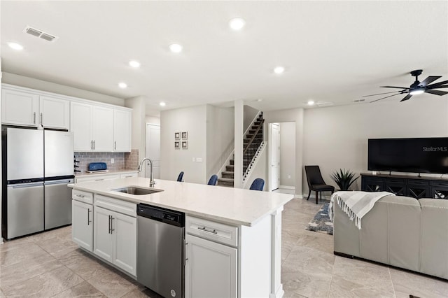 5065 Sparkling Water Way, Kissimmee, FL 34746 - kitchen with appliances with stainless steel finishes, open floor plan, tasteful backsplash, white cabinets, and a ceiling fan