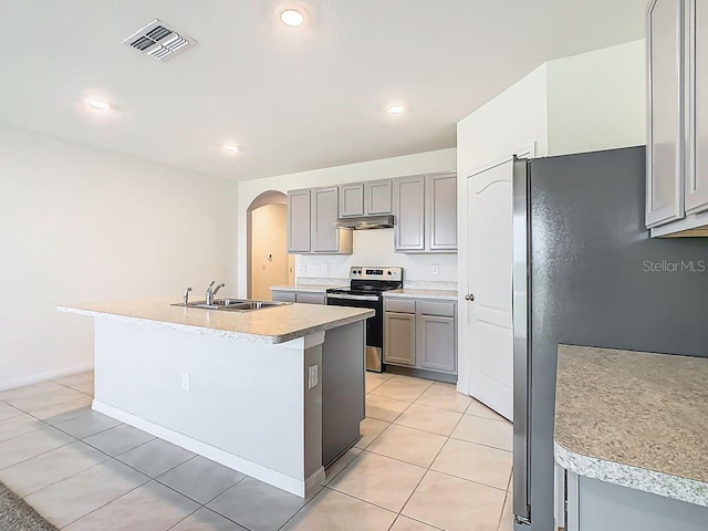 313 Sofia Ln, Lake Alfred, FL 33850 - kitchen with appliances with stainless steel finishes, gray cabinets, under cabinet range hood, arched walkways, and light tile patterned floors