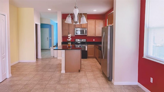 12630 Old Plantation Ln, Orlando, FL 32824 - kitchen with appliances with stainless steel finishes, dark countertops, a chandelier, a kitchen island, and pendant lighting
