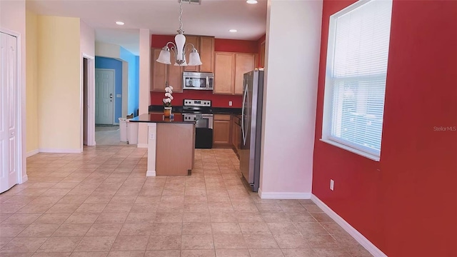 12630 Old Plantation Ln, Orlando, FL 32824 - kitchen featuring appliances with stainless steel finishes, a chandelier, a center island, dark countertops, and recessed lighting