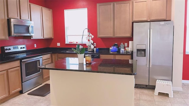 12630 Old Plantation Ln, Orlando, FL 32824 - kitchen featuring stainless steel appliances, a kitchen island, light tile patterned flooring, and dark stone counters