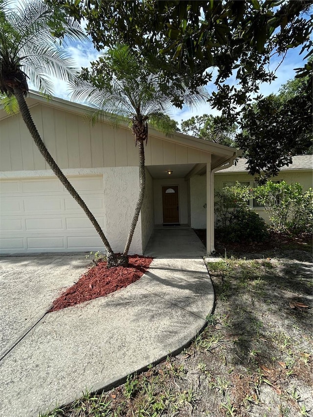9504 W Cluster Ave, Tampa, FL 33615 - view of exterior entry with an attached garage and stucco siding