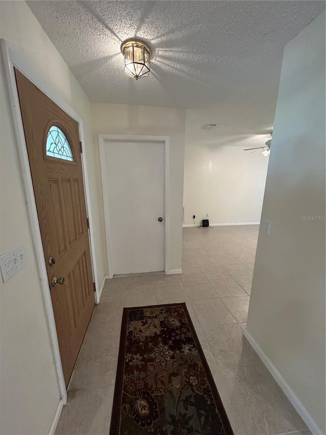 9504 W Cluster Ave, Tampa, FL 33615 - entrance foyer featuring a ceiling fan, a textured ceiling, and light tile patterned floors