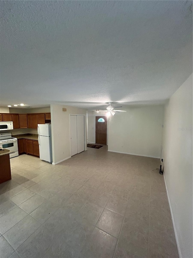 9504 W Cluster Ave, Tampa, FL 33615 - unfurnished living room featuring a ceiling fan, a textured ceiling, and light tile patterned flooring