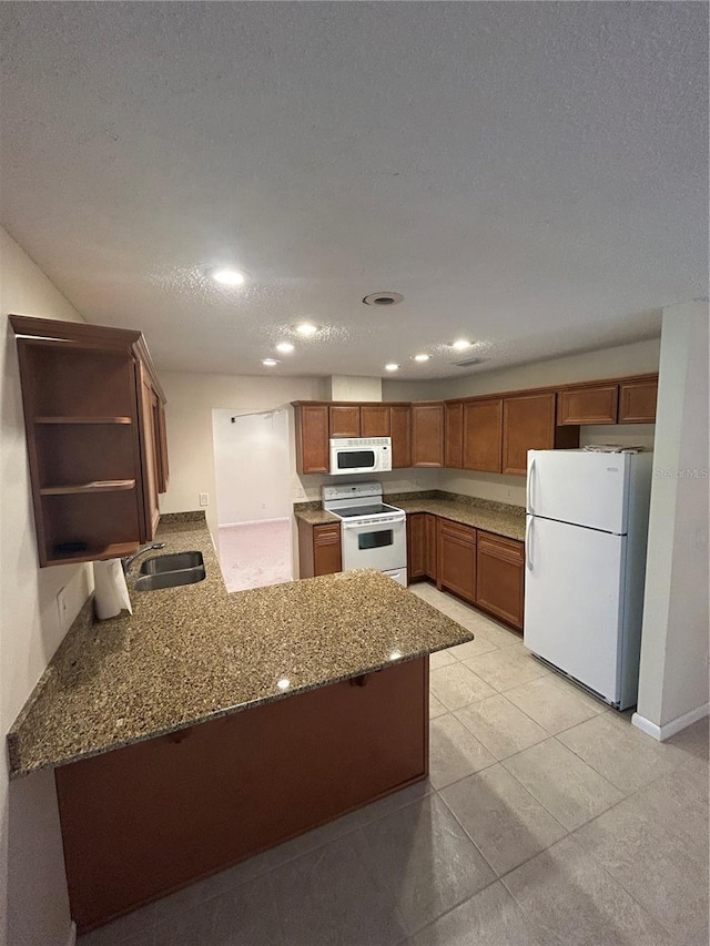 9504 W Cluster Ave, Tampa, FL 33615 - kitchen featuring white appliances, dark stone counters, brown cabinets, a peninsula, and open shelves