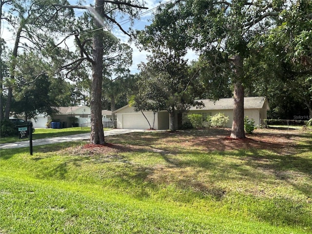 9504 W Cluster Ave, Tampa, FL 33615 - view of grassy yard featuring driveway and an attached garage