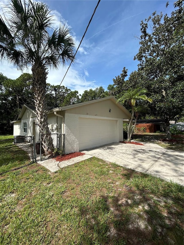 9504 W Cluster Ave, Tampa, FL 33615 - view of home's exterior with driveway, a garage, and a gate