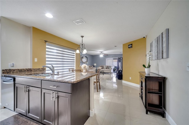 13217 Briar Forest Ct, Orlando, FL 32828 - kitchen with light stone countertops, open floor plan, pendant lighting, stainless steel dishwasher, and a peninsula