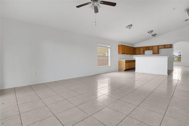 118 Sir Phillips Dr, Davenport, FL 33837 - unfurnished living room with vaulted ceiling, light tile patterned floors, arched walkways, and a ceiling fan
