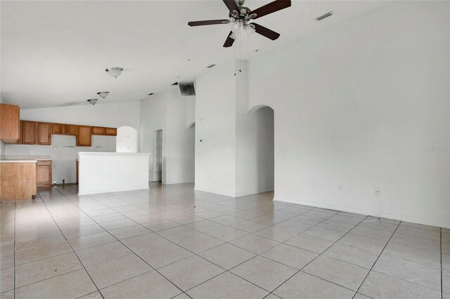 118 Sir Phillips Dr, Davenport, FL 33837 - unfurnished living room with arched walkways, ceiling fan, light tile patterned floors, and high vaulted ceiling