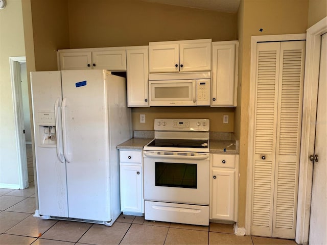 2207 Robel Trl, Clermont, FL 34714 - kitchen featuring white appliances, light tile patterned floors, vaulted ceiling, white cabinetry, and light countertops