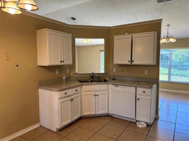 2207 Robel Trl, Clermont, FL 34714 - kitchen with dishwasher, light tile patterned floors, white cabinetry, a textured ceiling, and ornamental molding
