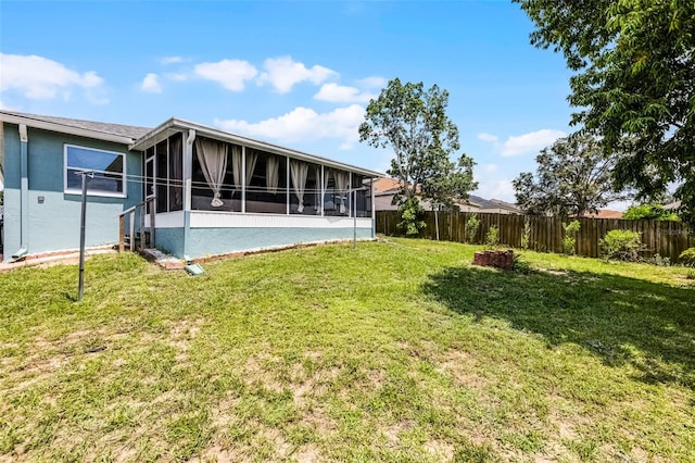141 Winsor Ave, Davenport, FL 33837 - back of property featuring a sunroom, a fenced backyard, and stucco siding