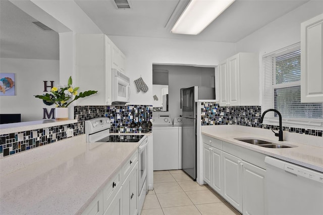 1649 Weybridge St, Deltona, FL 32725 - kitchen featuring white appliances, washer and clothes dryer, decorative backsplash, and white cabinets