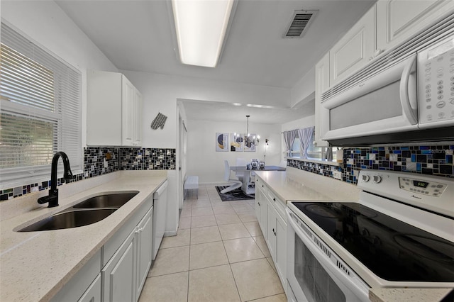 1649 Weybridge St, Deltona, FL 32725 - kitchen featuring white appliances, decorative backsplash, white cabinetry, light tile patterned floors, and light stone countertops