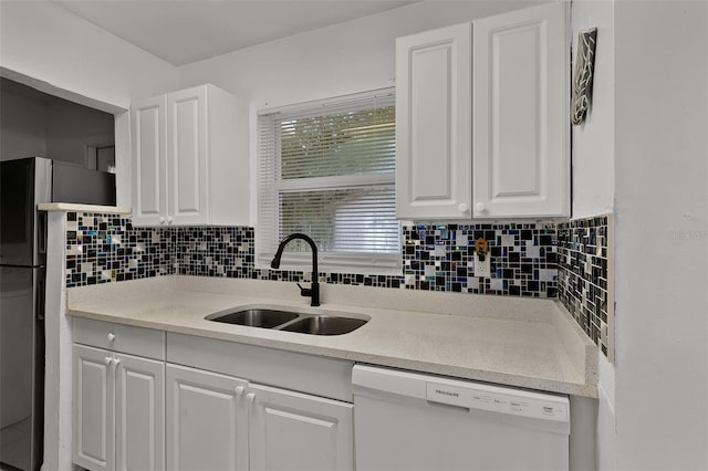 1649 Weybridge St, Deltona, FL 32725 - kitchen with white dishwasher, white cabinets, tasteful backsplash, light countertops, and freestanding refrigerator
