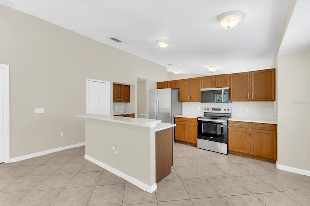1753 Sage Creek Ct, Orlando, FL 32824 - kitchen with stainless steel appliances, vaulted ceiling, light countertops, brown cabinetry, and light tile patterned floors