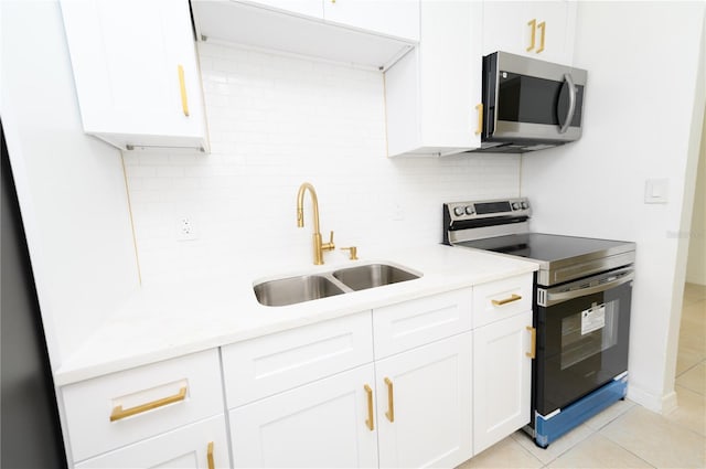 4469 Evers Pl, Orlando, FL 32811 - kitchen with stainless steel appliances, decorative backsplash, light countertops, white cabinetry, and light tile patterned flooring