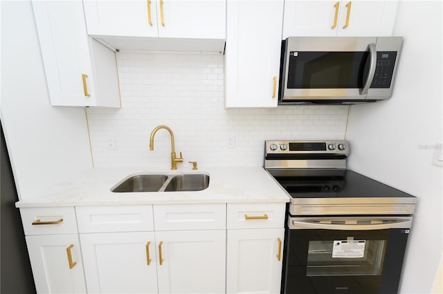 4469 Evers Pl, Orlando, FL 32811 - kitchen featuring stainless steel appliances, backsplash, white cabinets, and light stone countertops
