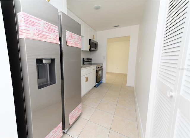 4469 Evers Pl, Orlando, FL 32811 - kitchen featuring appliances with stainless steel finishes, white cabinetry, light tile patterned flooring, and light countertops