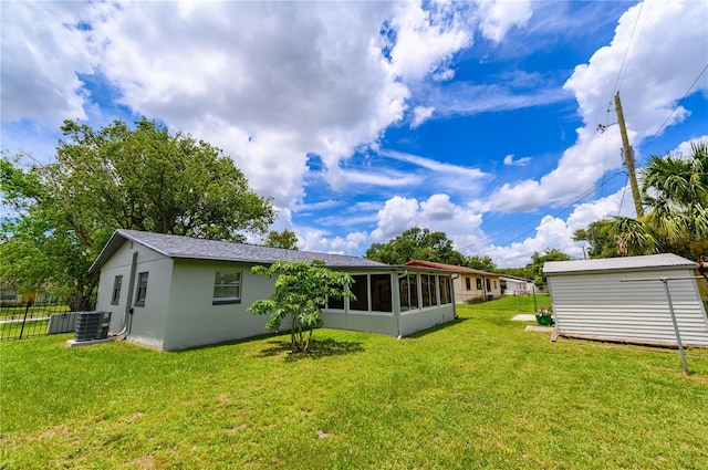 4469 Evers Pl, Orlando, FL 32811 - back of property featuring a sunroom, stucco siding, and a storage unit