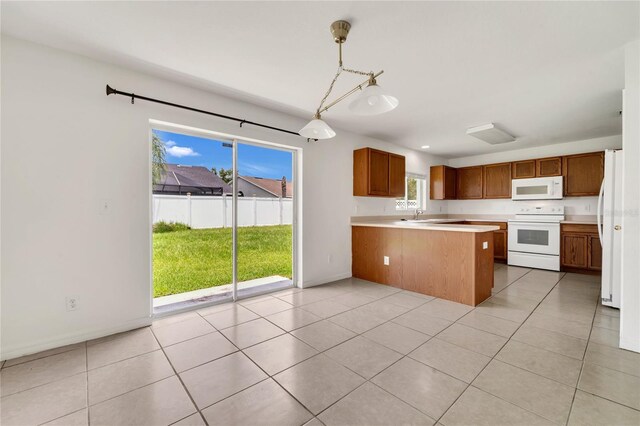 5145 Prairie View Way, Wesley Chapel, FL 33545 - kitchen featuring white appliances, a peninsula, light countertops, brown cabinets, and pendant lighting