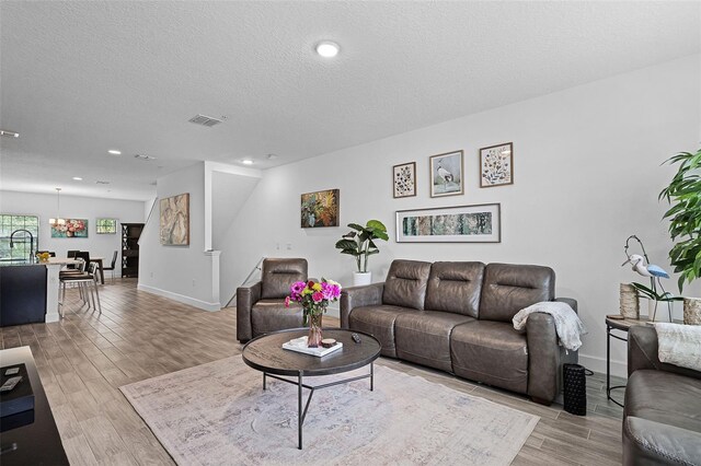 461 Diamond Dove Cv, Winter Springs, FL 32708 - living area featuring light wood-type flooring, a chandelier, a textured ceiling, and recessed lighting