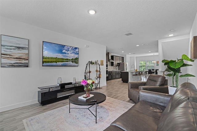461 Diamond Dove Cv, Winter Springs, FL 32708 - living room featuring light wood-style flooring, a textured ceiling, and recessed lighting