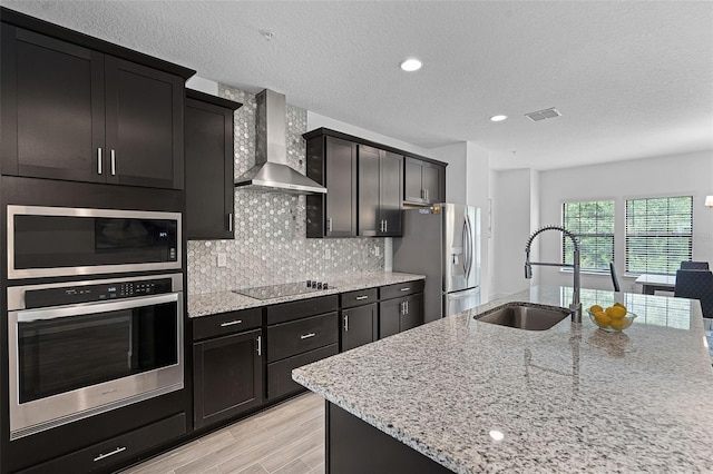 461 Diamond Dove Cv, Winter Springs, FL 32708 - kitchen featuring appliances with stainless steel finishes, wall chimney range hood, backsplash, light stone countertops, and light wood-style floors