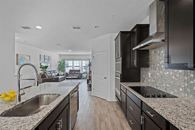 461 Diamond Dove Cv, Winter Springs, FL 32708 - kitchen with wall chimney range hood, stainless steel appliances, backsplash, recessed lighting, and light wood-style flooring