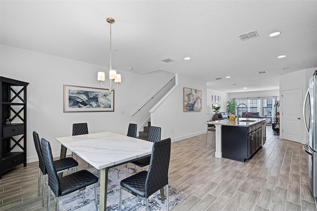 461 Diamond Dove Cv, Winter Springs, FL 32708 - dining space with light wood-type flooring, a chandelier, recessed lighting, and stairs
