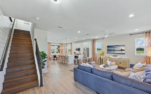 2563 Long Pine Ave, Apopka, FL 32712 - living room featuring plenty of natural light, ceiling fan, light wood finished floors, stairway, and recessed lighting