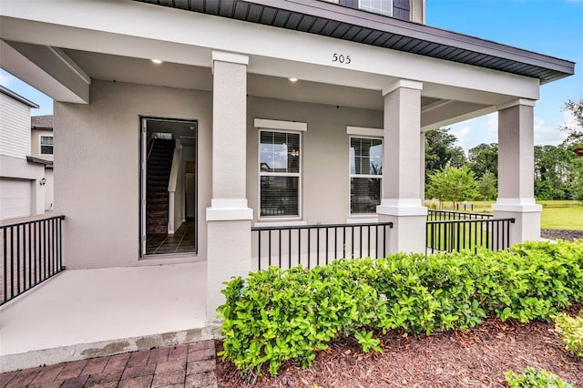 505 Venetian Palms Blvd, New Smyrna Beach, FL 32168 - doorway to property featuring a porch and stucco siding