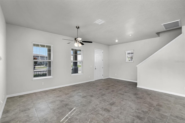 505 Venetian Palms Blvd, New Smyrna Beach, FL 32168 - unfurnished living room with a ceiling fan, a textured ceiling, and tile patterned floors