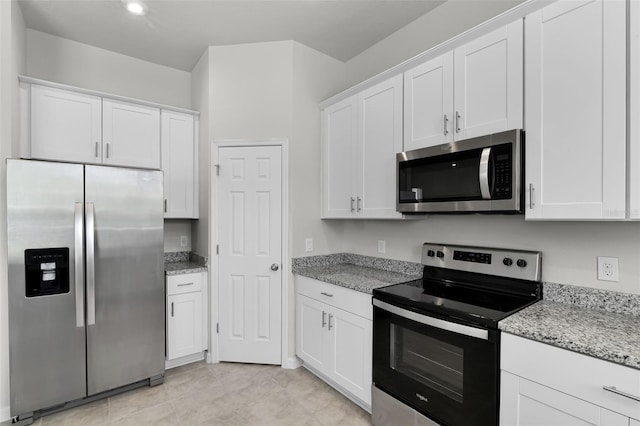 505 Venetian Palms Blvd, New Smyrna Beach, FL 32168 - kitchen featuring appliances with stainless steel finishes, white cabinetry, and light stone counters