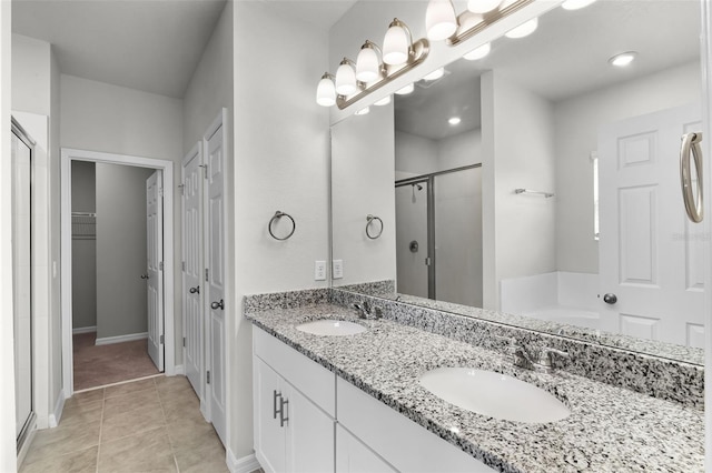 505 Venetian Palms Blvd, New Smyrna Beach, FL 32168 - bathroom with a stall shower, double vanity, tile patterned flooring, a bath, and a walk in closet