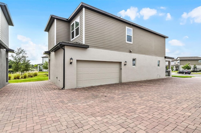 505 Venetian Palms Blvd, New Smyrna Beach, FL 32168 - view of side of property with a garage, stucco siding, and decorative driveway