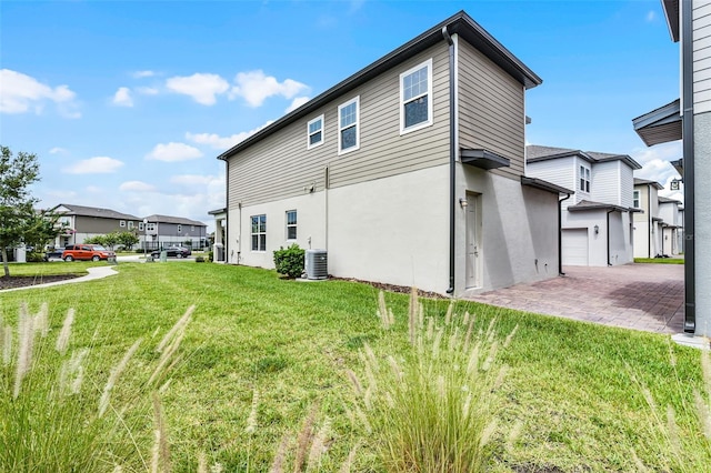 505 Venetian Palms Blvd, New Smyrna Beach, FL 32168 - view of side of property with a lawn, stucco siding, decorative driveway, a garage, and a residential view