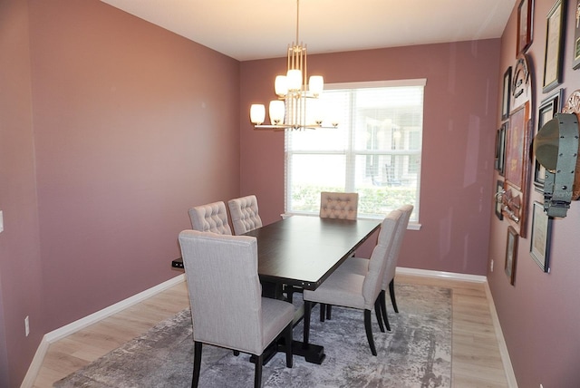 dining area with light wood-type flooring, a chandelier, and plenty of natural light