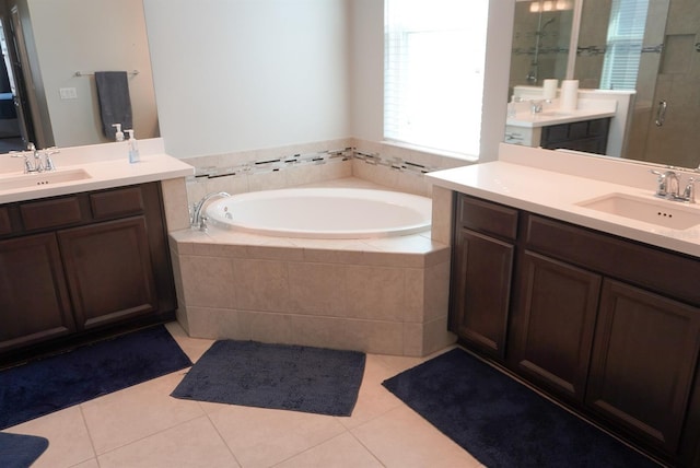 full bathroom with a shower stall, two vanities, a garden tub, and tile patterned floors