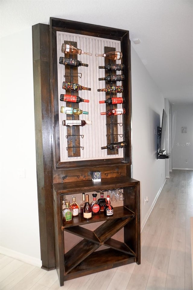 wine area featuring wood finished floors and baseboards