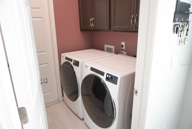 laundry area with washing machine and clothes dryer and cabinet space