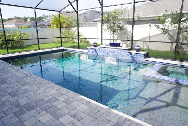 view of pool featuring a lanai, a pool with connected hot tub, and a patio