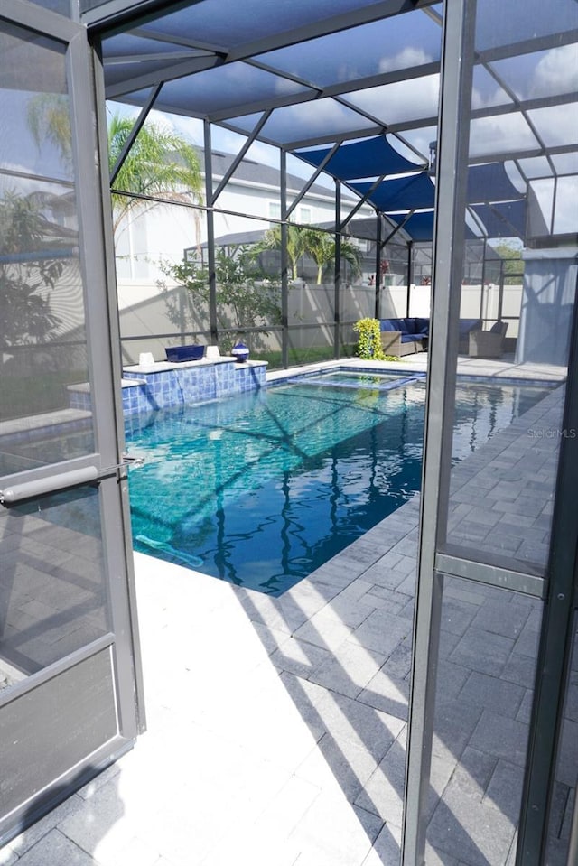 view of pool with a lanai, a jacuzzi, and a patio