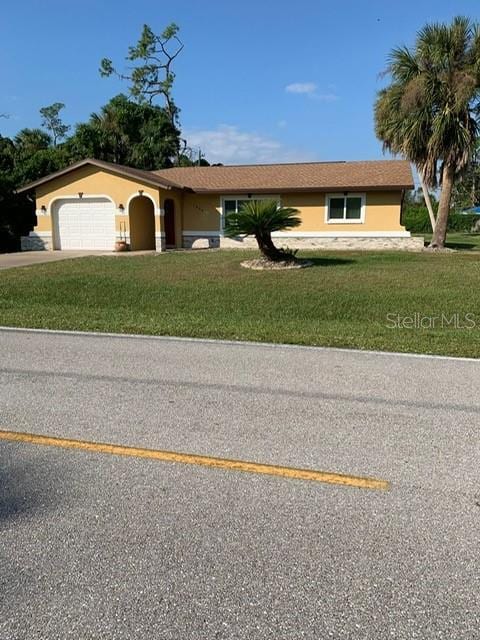 1409 Yorkshire St, Port Charlotte, FL 33952 - single story home featuring stucco siding, an attached garage, a front lawn, and concrete driveway