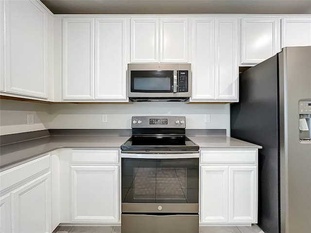 16436 Fernridge St, Clermont, FL 34714 - kitchen with appliances with stainless steel finishes, white cabinetry, and tile patterned flooring