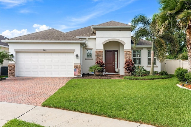 1181 Castlevecchio Loop, Orlando, FL 32825 - view of front of property featuring stucco siding, stone siding, decorative driveway, a garage, and roof with shingles