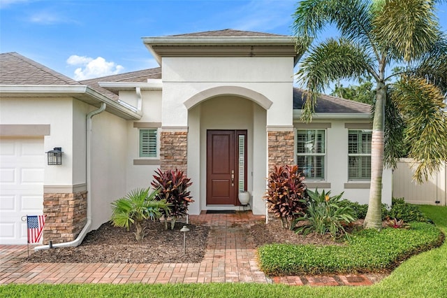 1181 Castlevecchio Loop, Orlando, FL 32825 - property entrance with stone siding, stucco siding, a garage, and a shingled roof