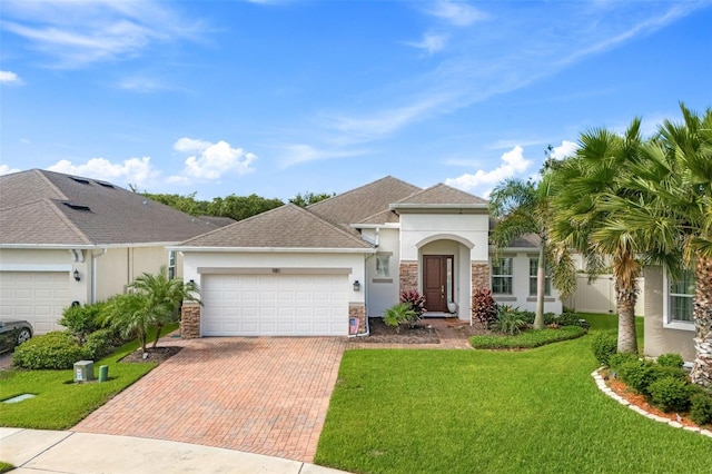 1181 Castlevecchio Loop, Orlando, FL 32825 - view of front of home with stucco siding, decorative driveway, a garage, a front yard, and stone siding